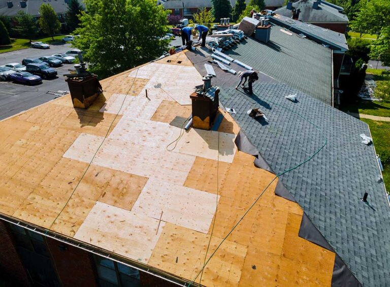 A house roof with a glass skylight and late-season snow, showing clear melt patterns and nearby shingles.