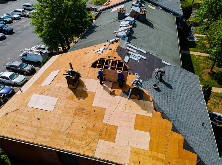 A residential roof with damaged shingles seen up close after a recent heavy storm.